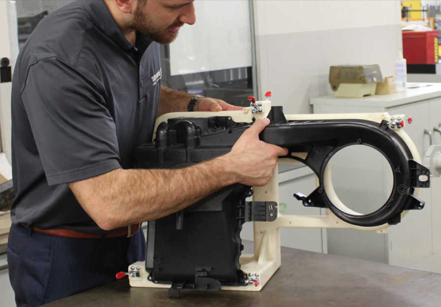 an engineer puts a 3d printed fixture to use