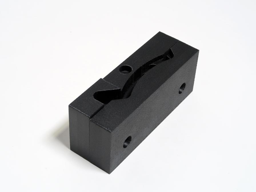 Soft jaws 3D printed in FDM Nylon 12CF carbon fiber material and the machined part these jaws hold during machining.