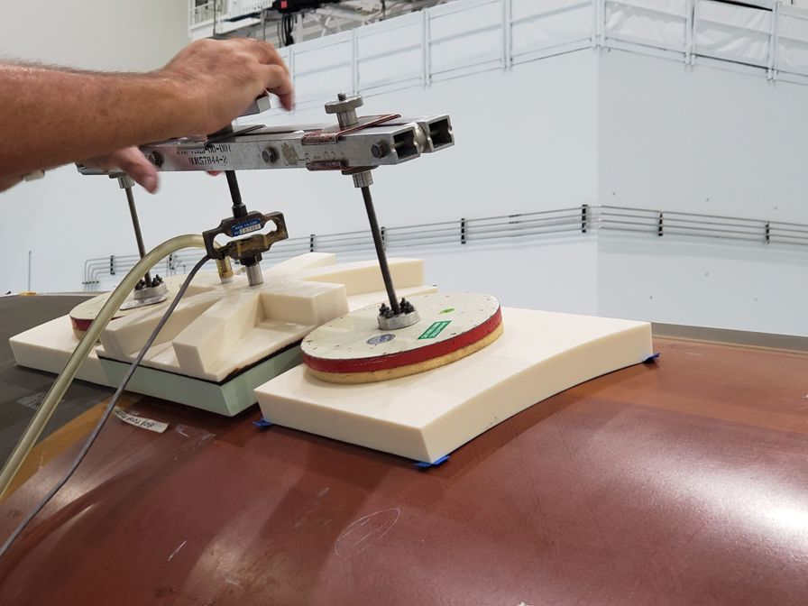 The 3D printed bond verification chuck (middle white block) used to adhere and check the thermal protection system tiles.
