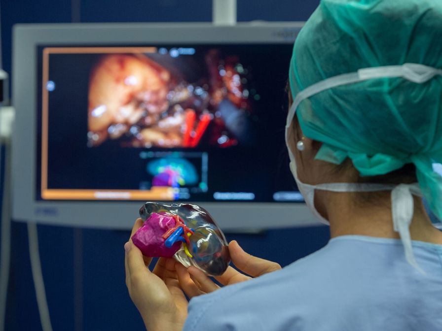 Trainee surgeon using a 3D printed model of a patient’s kidney in the operating theatre during a surgery.