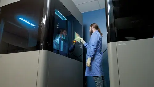 man pressing buttons on 3d printer