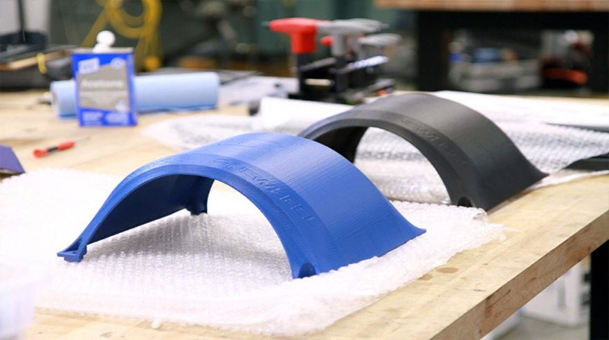 3D printed fender prototypes made from ASA (blue) and FDM Nylon 12CF (black).