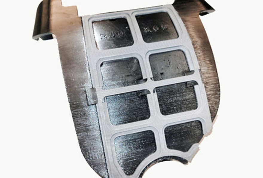 3D printed emblem locating fixture with carbon fiber frame (gray) and TPU backing.