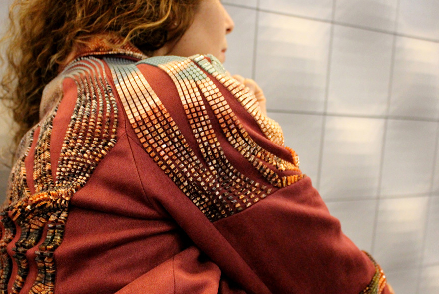 a woman wearing a jacket with 3d printed decorations on it