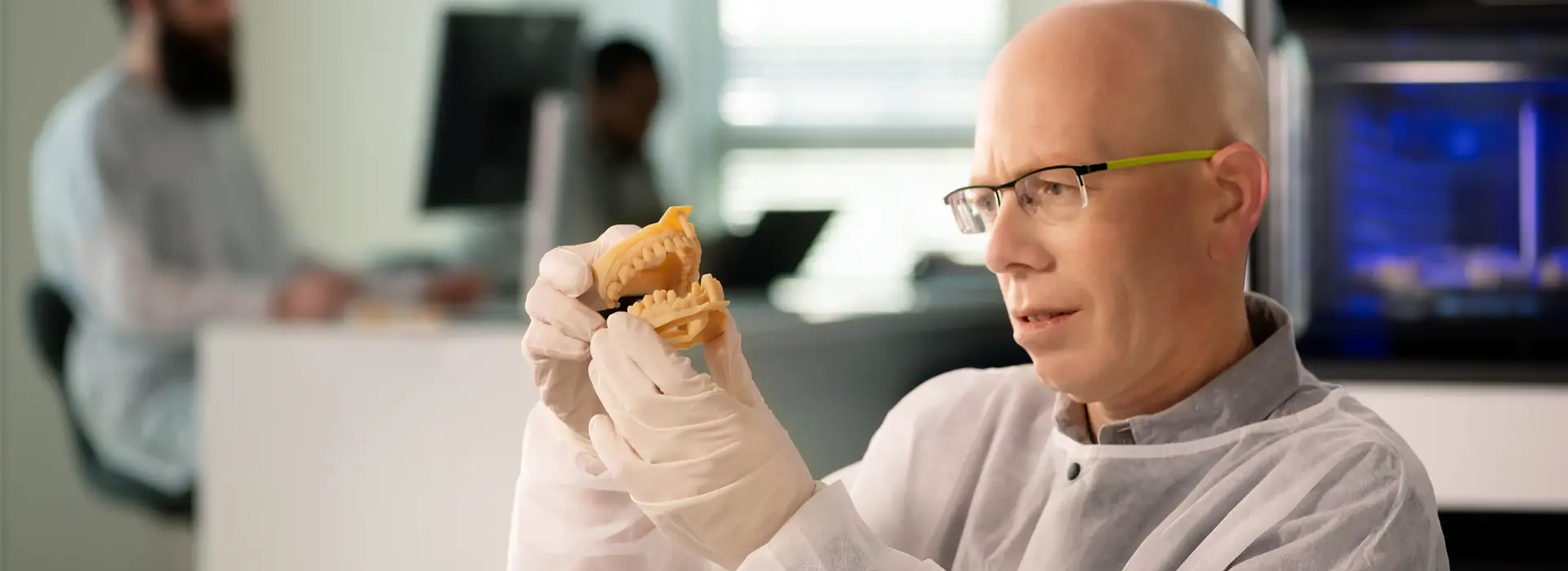 dental technician examining 3d printed denture model