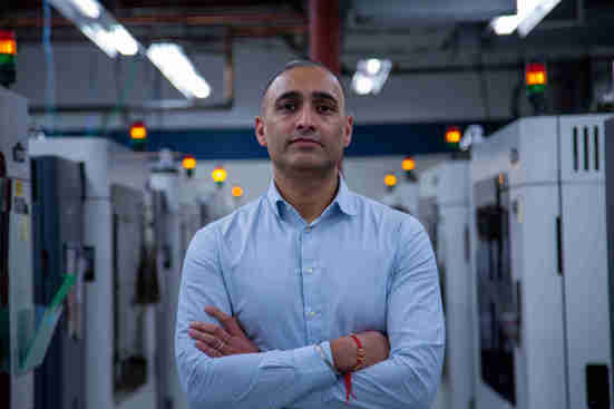 Gurvinder Kahlon VP and GM of Stratasys Direct standing in front of FDM 3d printing equipment