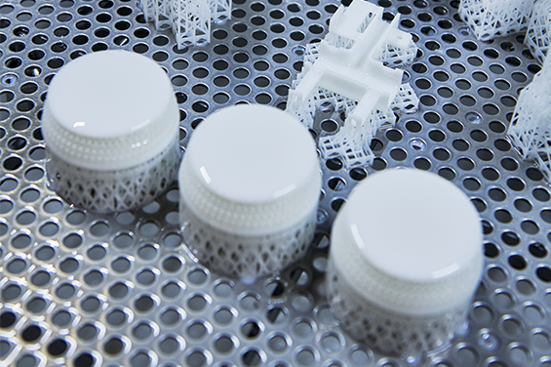 SLA 3D printed parts with support structures on a perforated metal tray