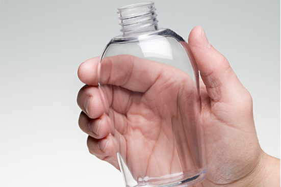 Hand holding a clear 3D printed plastic bottle with threaded neck