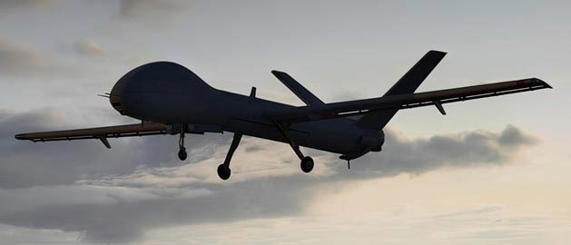 A drone in flight against a gray sky, featuring aerodynamic parts made using additive manufacturing