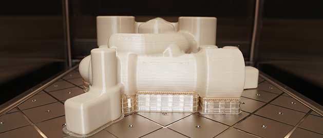 FDM 3D printed part on build plate headed to finishing.