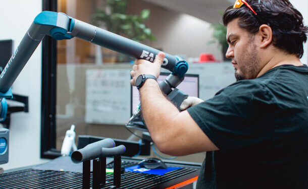 Man inspecting SLS 3D Printed part using CMM Stratasys Direct